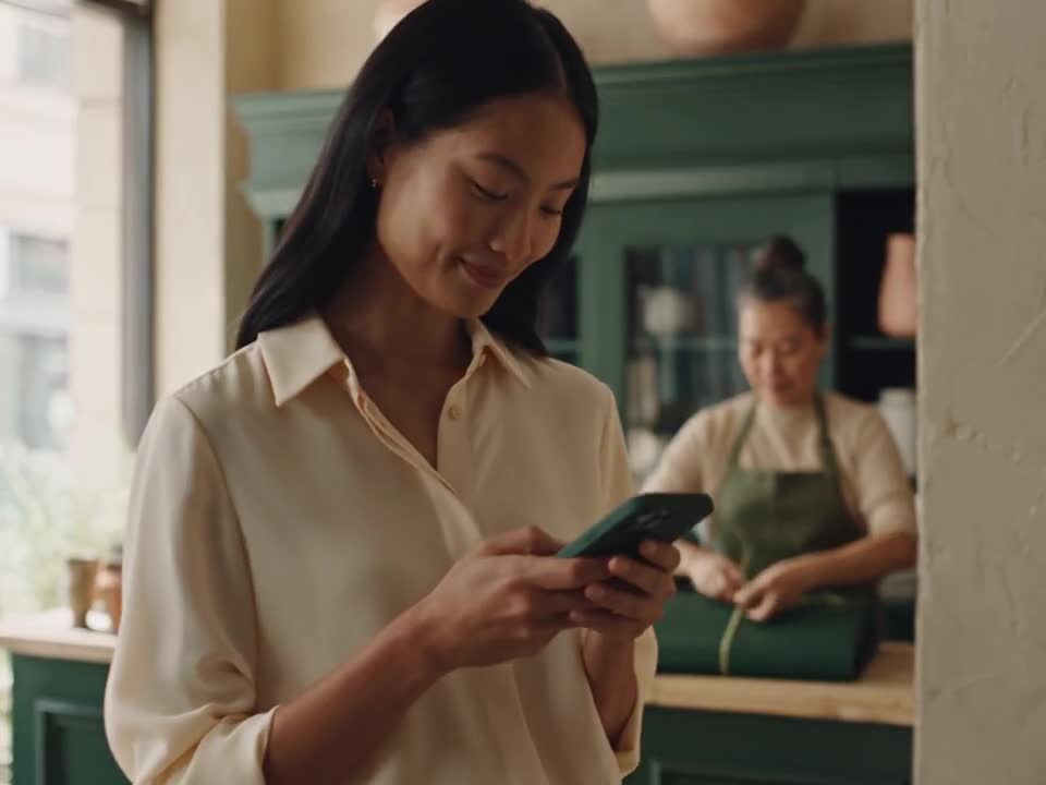 A customer checking her phone in an independent homeware shop.