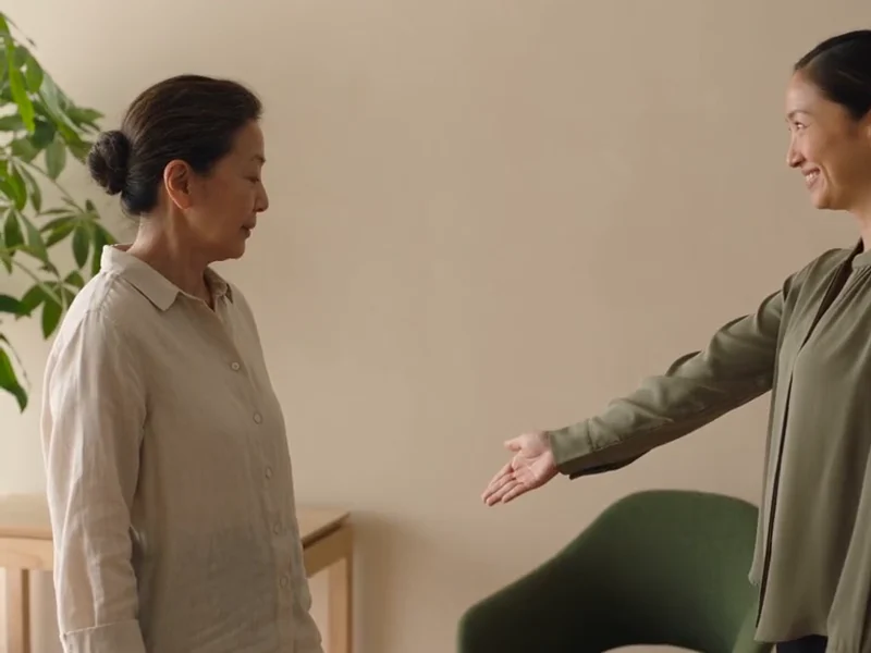 A guest and a receptionist share a warm, considerate welcome in a studio.